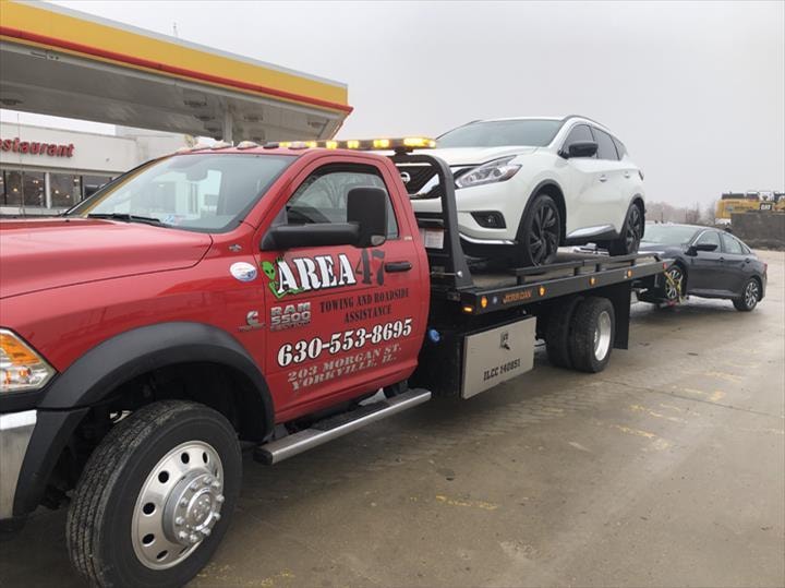 Area 47 red tow truck carrying white SUV